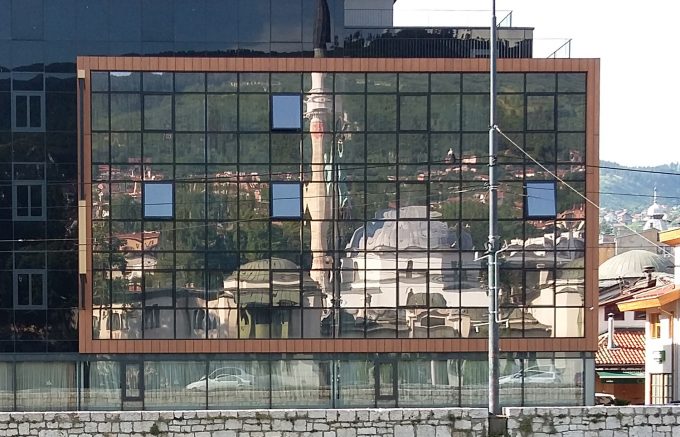 Eine Moschee spiegelt sich in der Glasfassade eines Hauses in Amman - Foto: Ann Klage